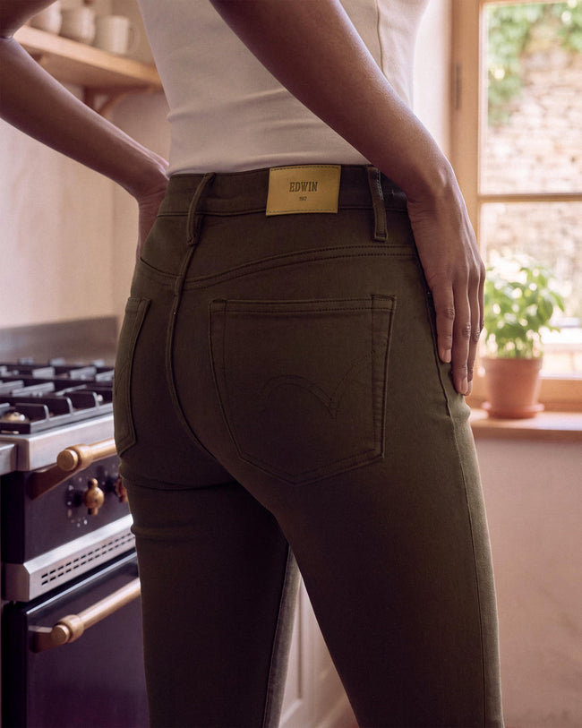 Women's skinny jeans close-up: olive-brown denim with front pockets and belt loops
